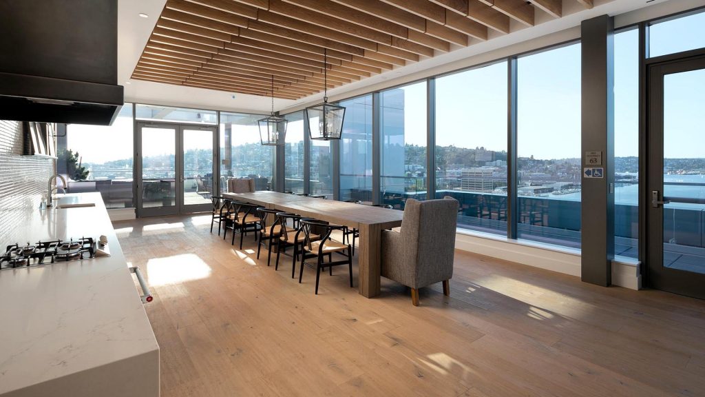 Rooftop kitchen and dining area with large dining table and views of city