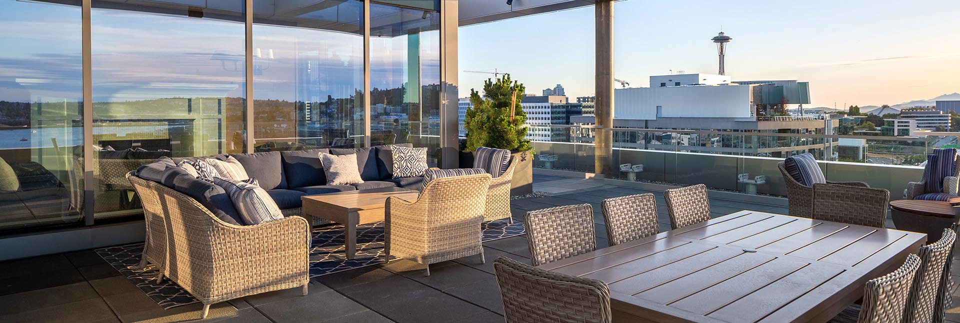 Rooftop seating area and dining table with city and Space Needle in background